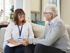 Female Support Worker Visits Senior Man At Home